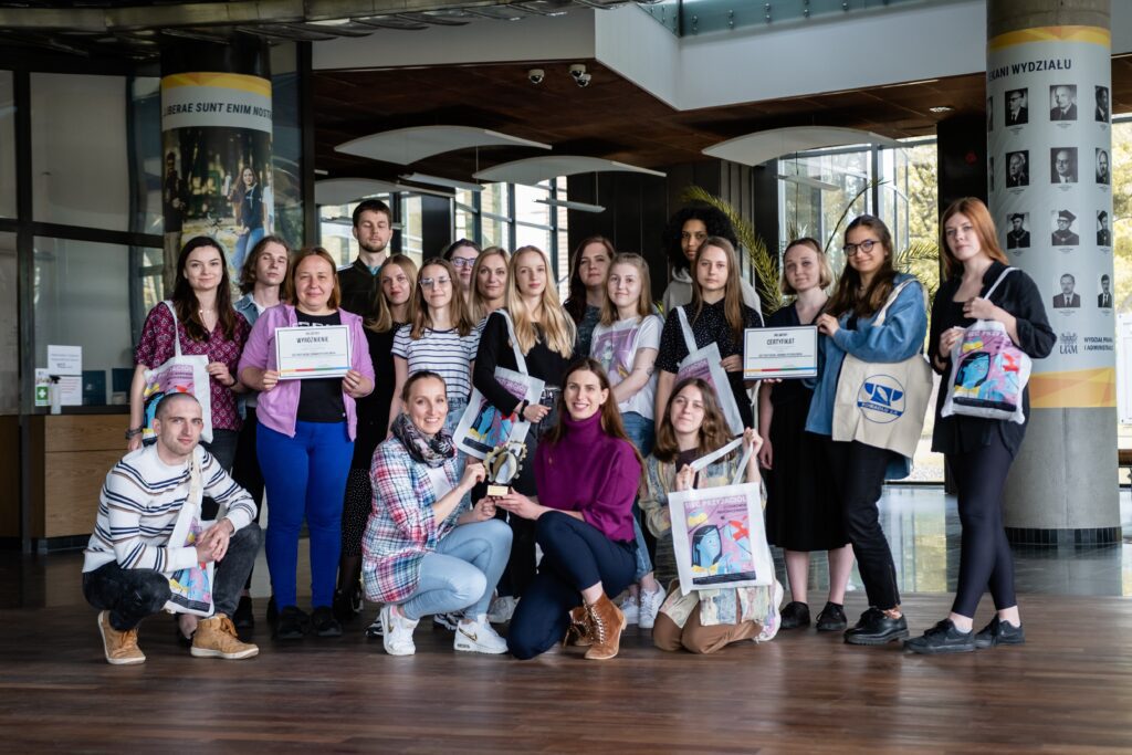 wolontariusze prezentujący certyfikaty i nagrodę za projekt